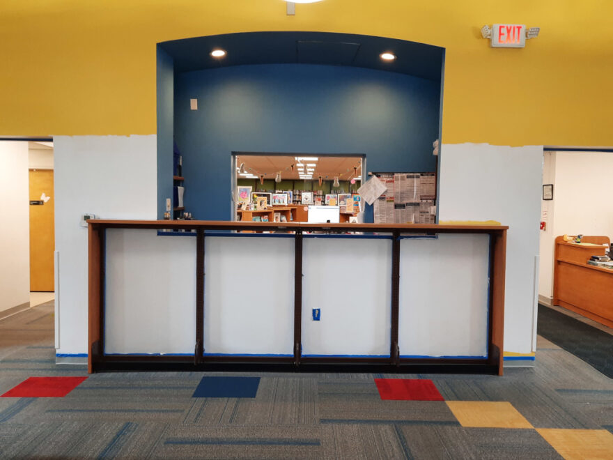 Wall of the Maxwell Library Youth area near the beginning of the project. Bottom half has been painted white, but the top half has yet to be painted & is still yellow.
